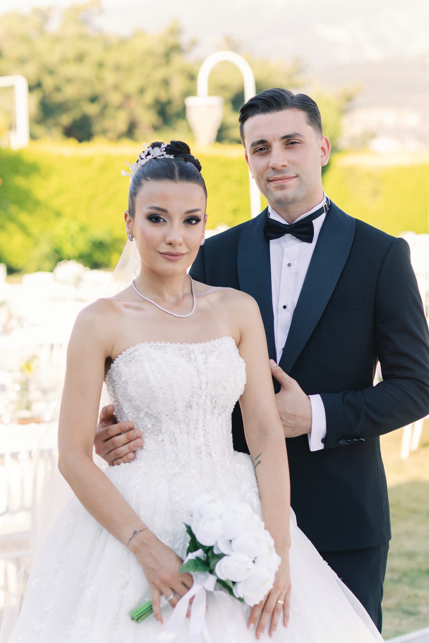 Bahçede yan yana portre veren gelin ve damat